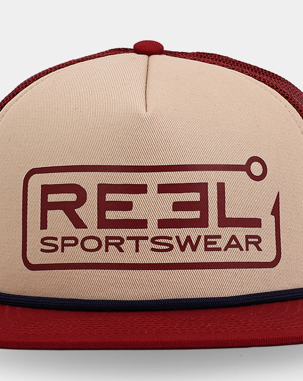 Reel Sportswear Dawson Trucker Hat — close-up of hook-and-line framed logo graphic printed in deep red on tan structured front panel