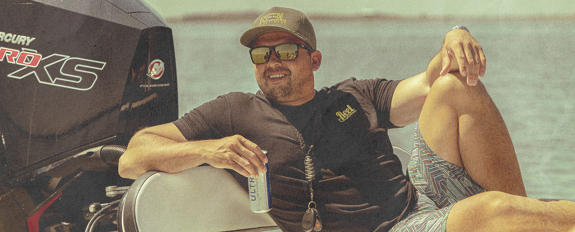 Jeremey Torres chillin on the deck of a boat with a beer and Reel Sportswear