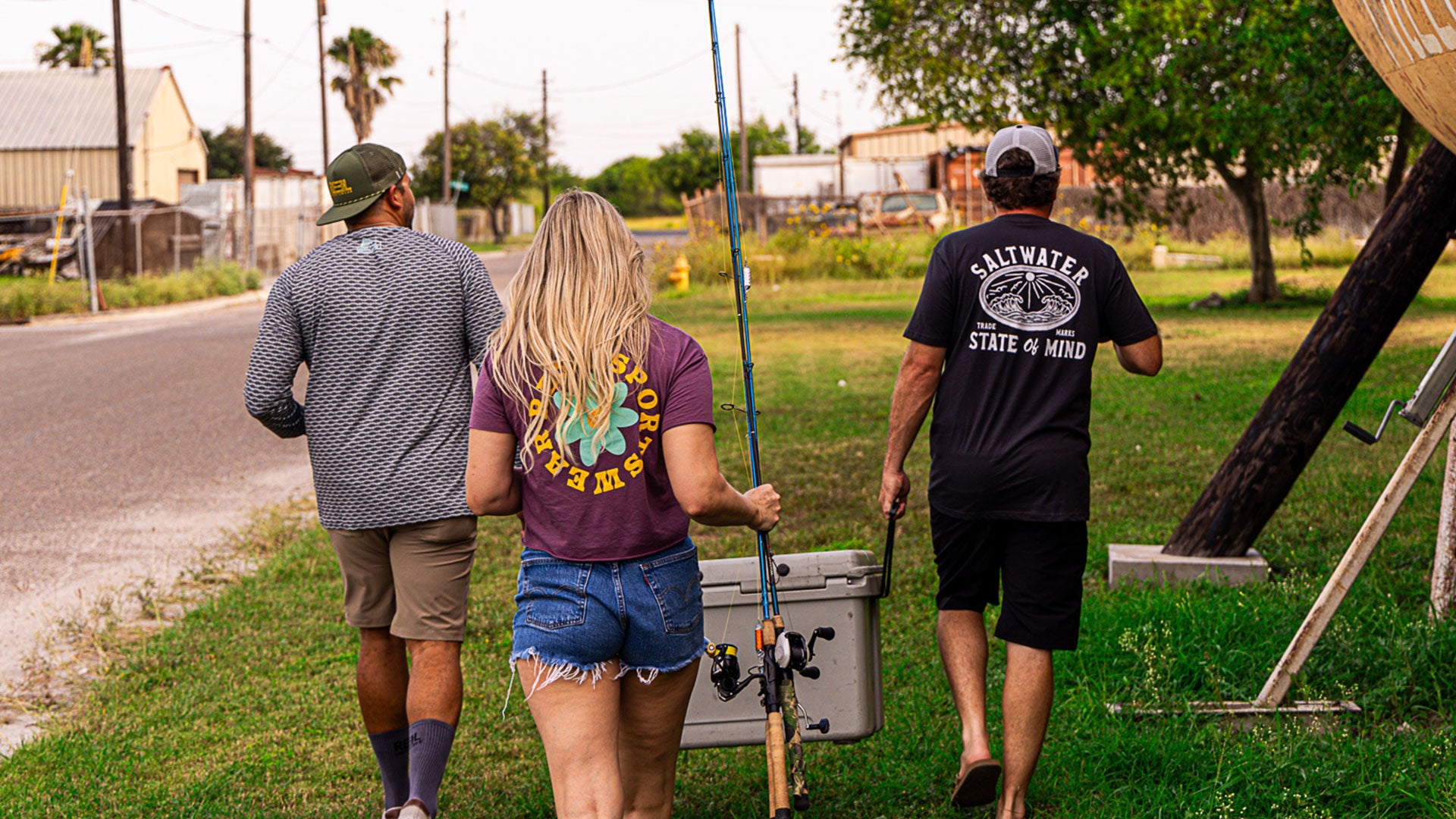 Reel Sportswear Crew walking with cooler and fishing poles headed to the beach to fish. Fishing Apparel, Corpus Christi, Texas
