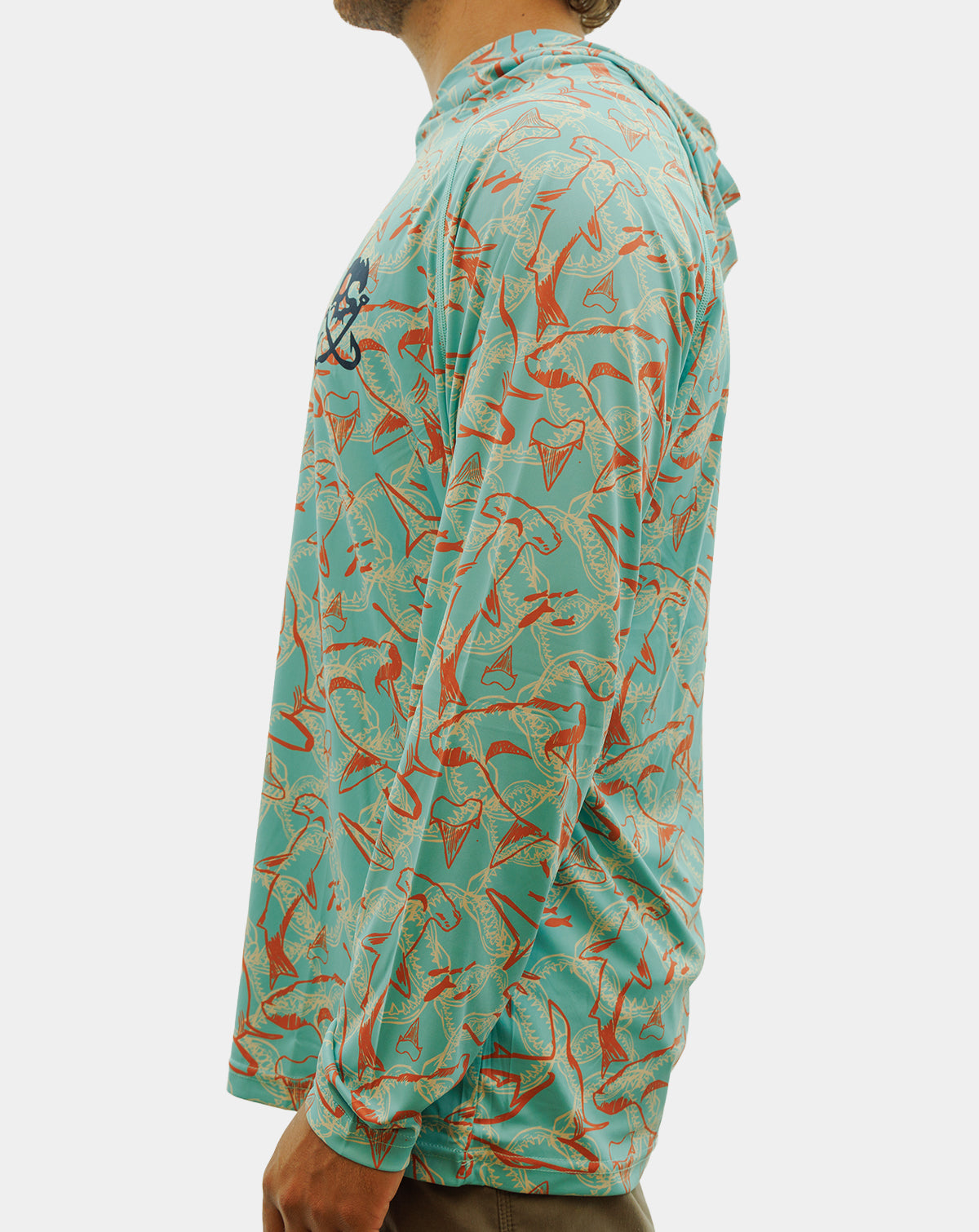 A man wearing a long-sleeve hooded performance shirt with a turquoise and orange fish pattern, featuring a black and white skull-and-crossbones logo on the left chest. Reel Sportswear Scurve fishing Hoody